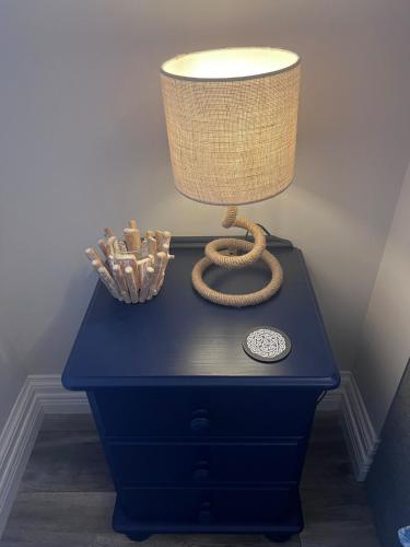 a blue table with a lamp on top of it at The C Den Amazing Seaview, ground floor, free wifi & parking in Whitehead