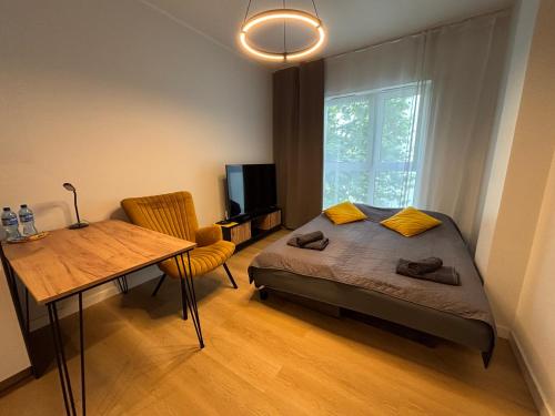 a bedroom with a bed and a table and a window at TOTU TODAY-PLAC WOLNOŚCI 6 APARTAMENTY, Faktura VAT, self check-in in Poznań