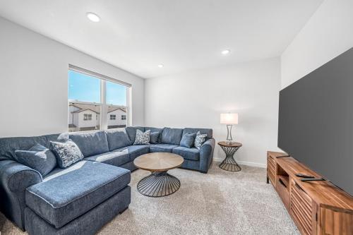 a living room with a blue couch and a tv at Townhome near Tarleton! in Stephenville