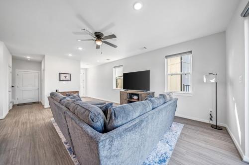 a living room with a couch and a flat screen tv at Townhome near Tarleton! in Stephenville