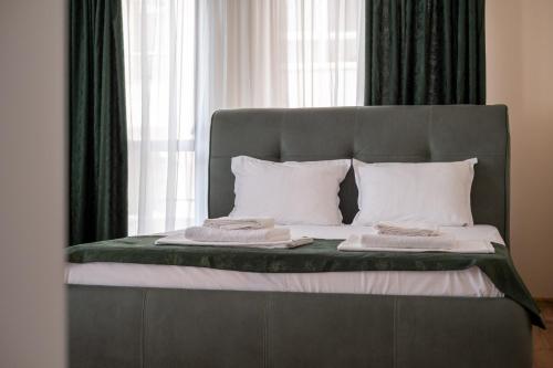 a bed with white pillows and a gray head board at 5 Villa Vitosha Classic Stays in Hisarya
