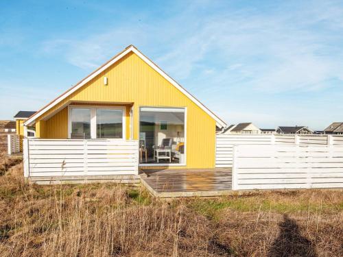 a yellow and white house on the beach at 4 person holiday home in Lemvig in Lemvig