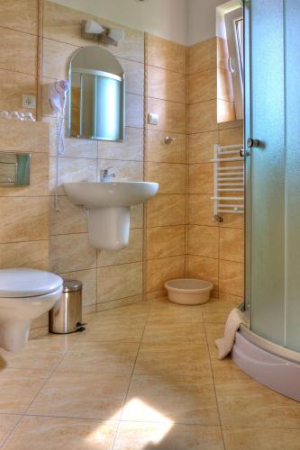 a bathroom with a sink and a toilet and a shower at Pensjonat Dolce Vita & SPA in Ustronie Morskie