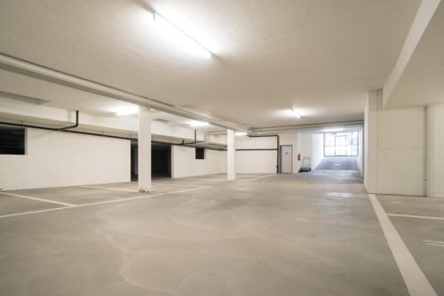 an empty parking garage with a large room with white columns at RIVER Apartment in Arni Alp