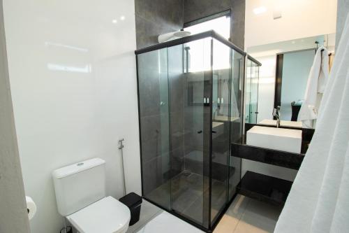 a bathroom with a shower and a toilet and a sink at Entre Serras & Águas in Capitólio
