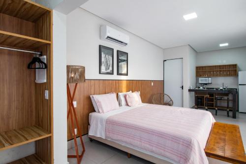 a bedroom with a large bed and a kitchen at Entre Serras & Águas in Capitólio