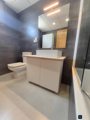 a bathroom with a sink and a toilet and a mirror at Soleil-Sérénité Golf Aguilón in Pilar de Jaravía