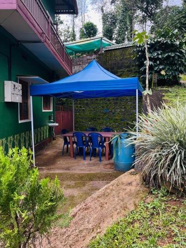 a blue tent sitting outside of a house at Quiet quarters Estate Stay in Napoklu