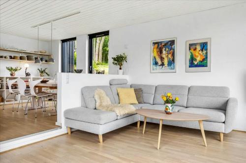a living room with a couch and a table at Summer House Close To Nature By The Limfjord in Nykøbing Mors