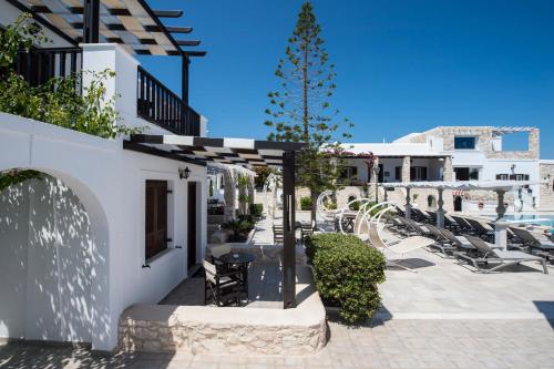 a patio of a hotel with a table and chairs at Contaratos Beach Hotel in Naousa