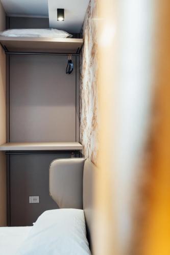 a small bedroom with a bed and a shelf at Central Suites in Chieti