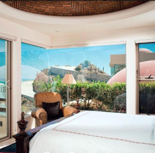 a bedroom with a view of the ocean through a window at Luxury Cabo Villa Stunning Ocean Views in Cabo San Lucas