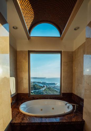 a bath tub in a bathroom with a large window at Luxury Cabo Villa Stunning Ocean Views in Cabo San Lucas
