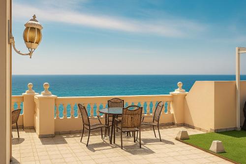 a balcony with a table and chairs and the ocean at Apartamentos Balcon de Carabeo in Nerja