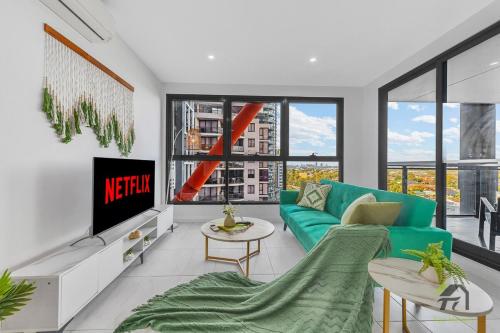 a living room with a green couch and a tv at Parramatta 2 Bedroom Elegant Home in Sydney
