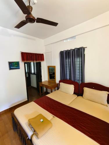 a bedroom with two beds and a ceiling fan at Tamaara inn beach resort in Varkala
