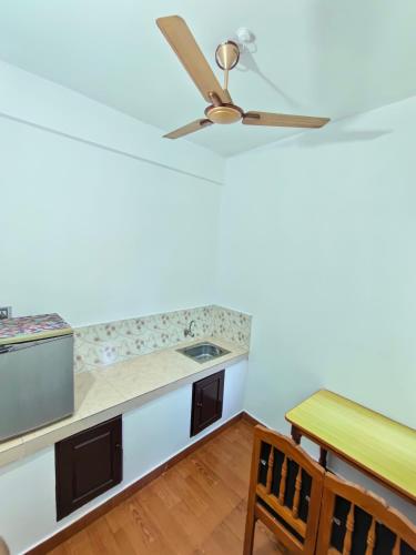 a kitchen with a ceiling fan and a table at Tamaara inn beach resort in Varkala