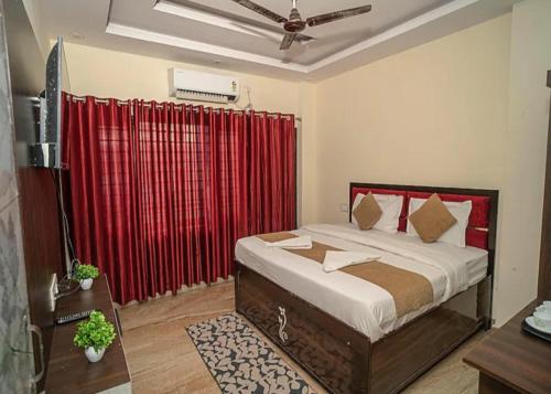 a bedroom with a bed with a red curtain at Hotel Namo Gange in Rishīkesh