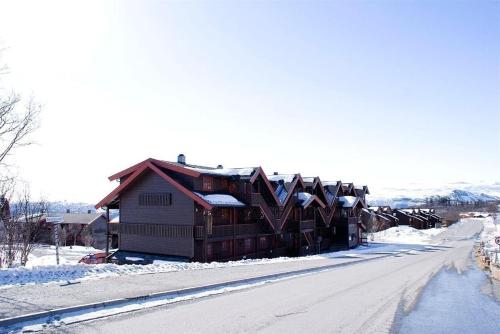 Una cabaña de troncos en la nieve en una calle en Central on Beitostølen with walking distance to everything, en Beitostølen