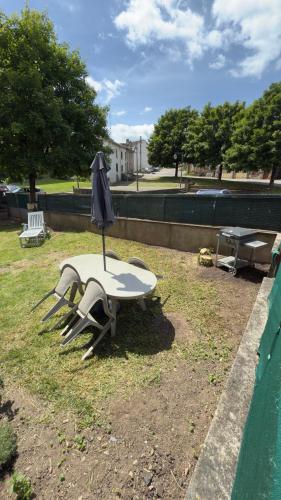 a picnic table with two chairs and an umbrella at Le Gîte de L'Etoile in Baccarat