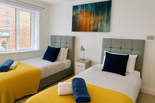 two beds sitting next to each other in a bedroom at Harry Potter Stay - Watford & London Links - Large Family in Abbots Langley