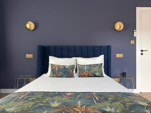 ein blaues Schlafzimmer mit einem großen Bett mit zwei Kissen in der Unterkunft ROOT by the River in Pedorido