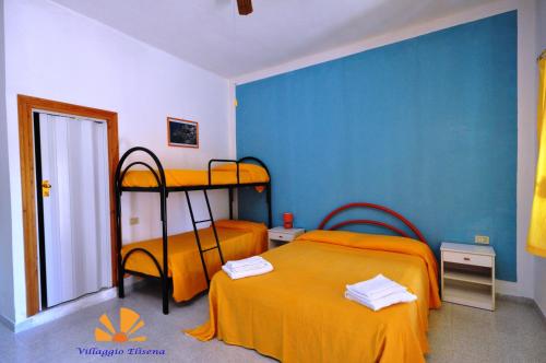 a bedroom with two bunk beds and a blue wall at Villaggio Elisena in Vieste