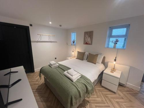 a bedroom with a large bed with a green blanket at Eleven on Dragon - Boutique Hotel Rooms & Studio Apartment in Harrogate