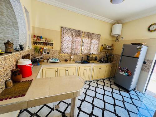 a kitchen with a refrigerator and a table in it at Villa Privée avec Piscine et Calme Absolu 