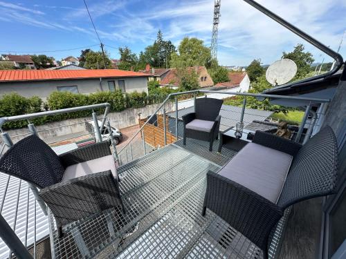 a balcony of a house with chairs on it at Große Ferienwohnung Gästehaus NEUBAU Merzig 120m2 in Merzig