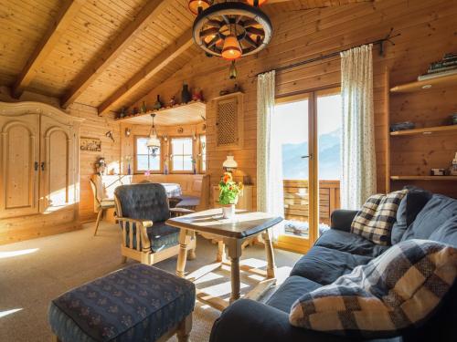 a living room with a blue couch and a table at Chalet on the slopes in Piesendorf