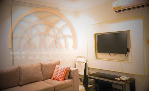 a living room with a couch and a flat screen tv at بروج السالمية للشقق المخدومة Brouj Al salmiya apartments Serviced in Dammam
