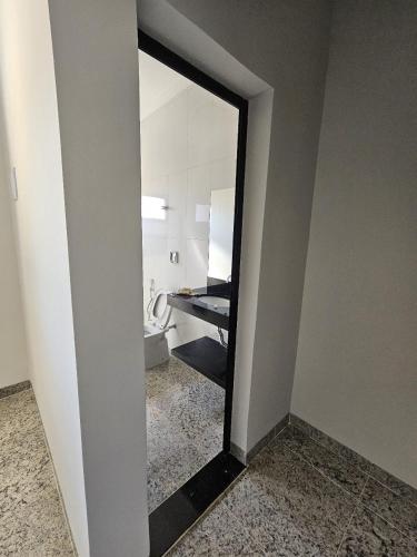 a mirror in a bathroom with a sink and a toilet at Estância Ana S Diniz in Barretos