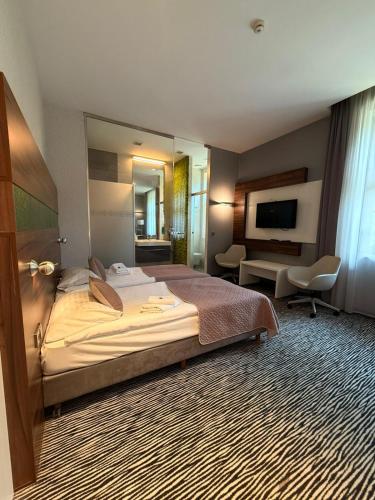 a hotel room with a large bed and a television at Hotel Gorczowski Katowice Chorzów in Chorzów