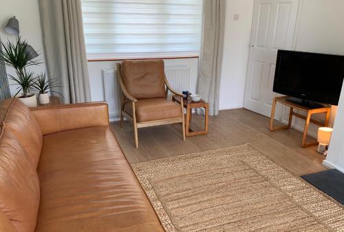 a living room with a couch and a chair and a television at 2 Bed-Sleeps 4-Parking-Pets-10 min walk to Beach in Falmouth