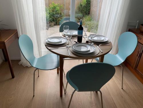 a table with blue chairs and a bottle of wine at 2 Bed-Sleeps 4-Parking-Pets-10 min walk to Beach in Falmouth
