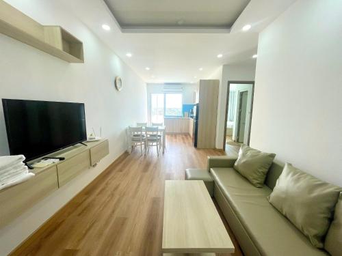 un salon avec un canapé et une télévision à écran plat dans l'établissement Blue Sea Hon Chong - Beachfront Apartment, à Nha Trang