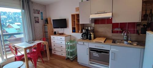 a kitchen with a sink and a table with chairs at studio Loubat pyrénée, ménage inclus in Arette