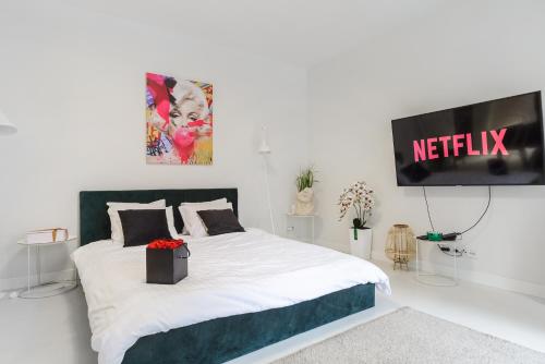 a bedroom with a bed with a television on the wall at Lumina Deluxe Warsaw in Warsaw