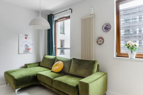 a green couch in a living room with a window at Lumina Deluxe Warsaw in Warsaw