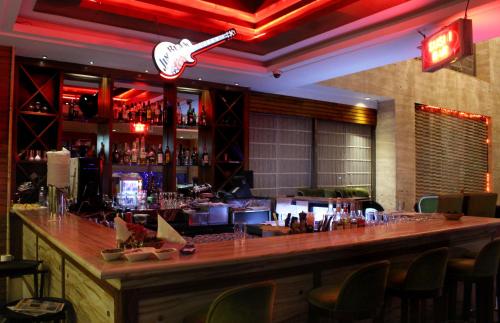 a bar in a restaurant with a long counter at SkyCity Hotel Gurgaon in Gurgaon