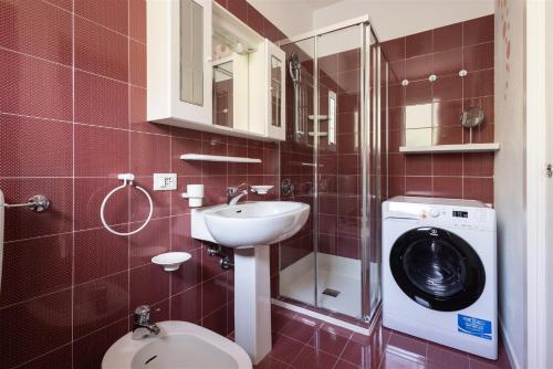 Un baño con lavadora y lavabo. en IseoLakeRental - Dream House, en Riva di Solto