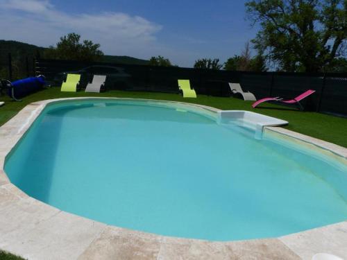 a large swimming pool with blue water in a yard at La fontaine de rocoule in Rochefort-en-Valdaine