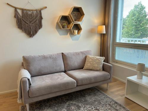 a living room with a couch and a window at City Home Aapeli in Kuopio