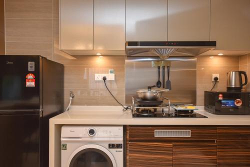 a kitchen with a dishwasher and a stove and a washer at R&F Princess Cove by Nest Home at Johor Bahru in Johor Bahru