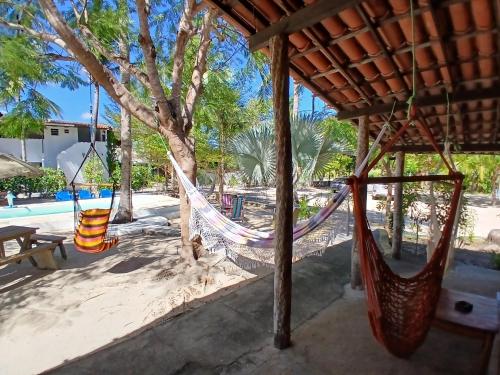 a hammock hanging from a pavilion at a beach at Pousada Unidos in Jijoca de Jericoacoara