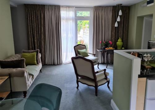 a living room with a couch and a chair at Palm Grove Apartments in Torquay