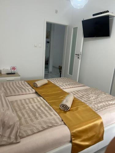 a bedroom with two beds and a flat screen tv at Wellness Way in Dunajská Streda