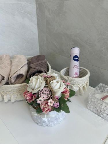 a bouquet of flowers and a bottle of lotion on a table at Wellness Way in Dunajská Streda