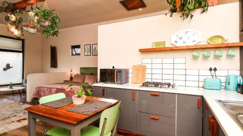 a kitchen with a table and a room with a bed at De Jagers Studio on Rawson in Knysna